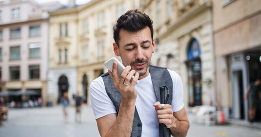Blind man on the street using voice commands on the phone without privacy
