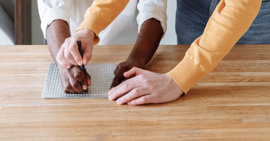 Student learning to write in Braille