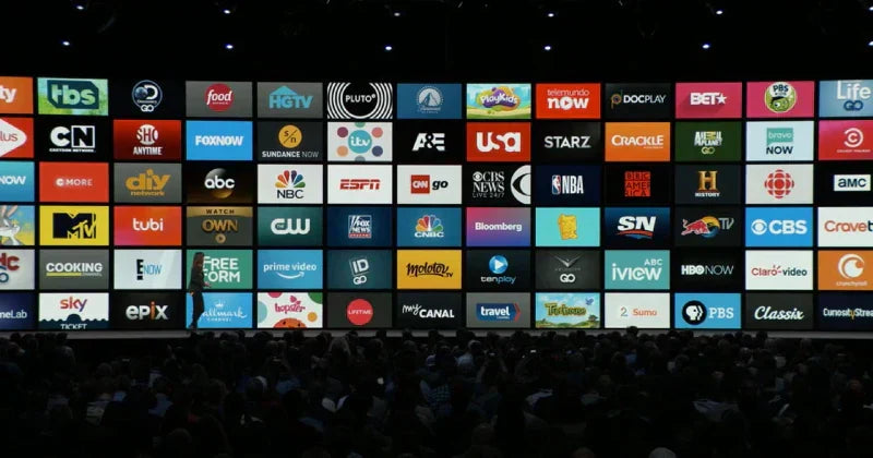 Large screen displaying a grid of streaming and network TV service logos to an audience.