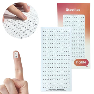 A composite image featuring the Hable Stactiles 180-count Braille sticker set. A circular inset shows fingers scanning across a dense sheet of small white stickers. A single sticker with the letter "H" and its Braille dots is shown on a fingertip for size comparison. The background displays the full sheet, organized alphabetically with multiple copies of each letter and punctuation marks, next to the retail packaging.
