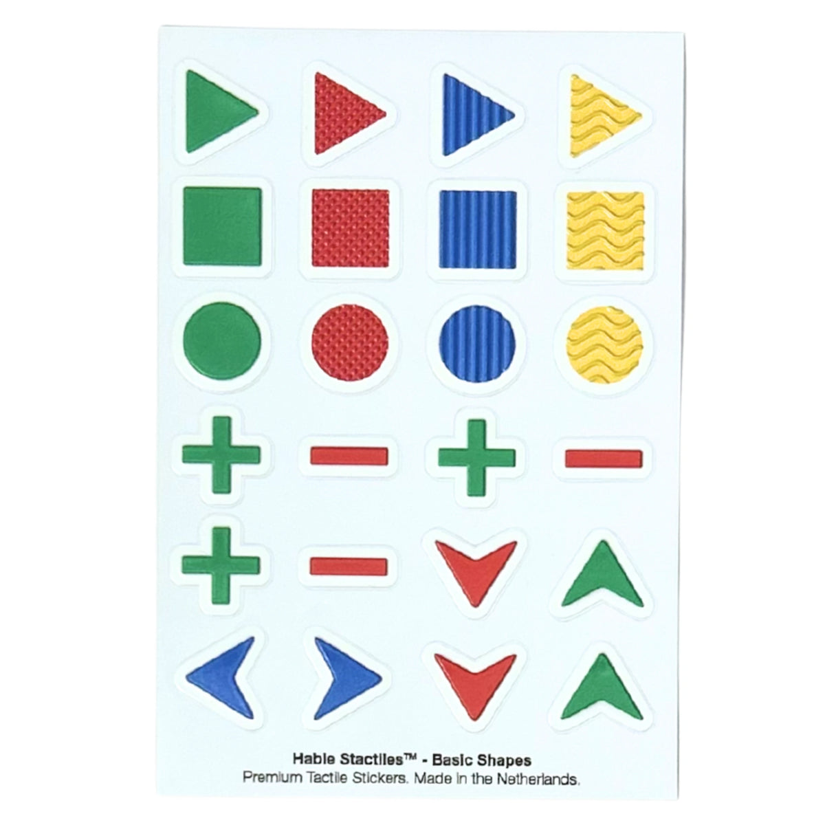 Top-down view of the "Hable Stactiles - Basic Shapes" sticker sheet. It features rows of tactile green, red, blue, and yellow geometric shapes, including textured triangles, squares, circles, plus and minus signs, and directional chevrons.