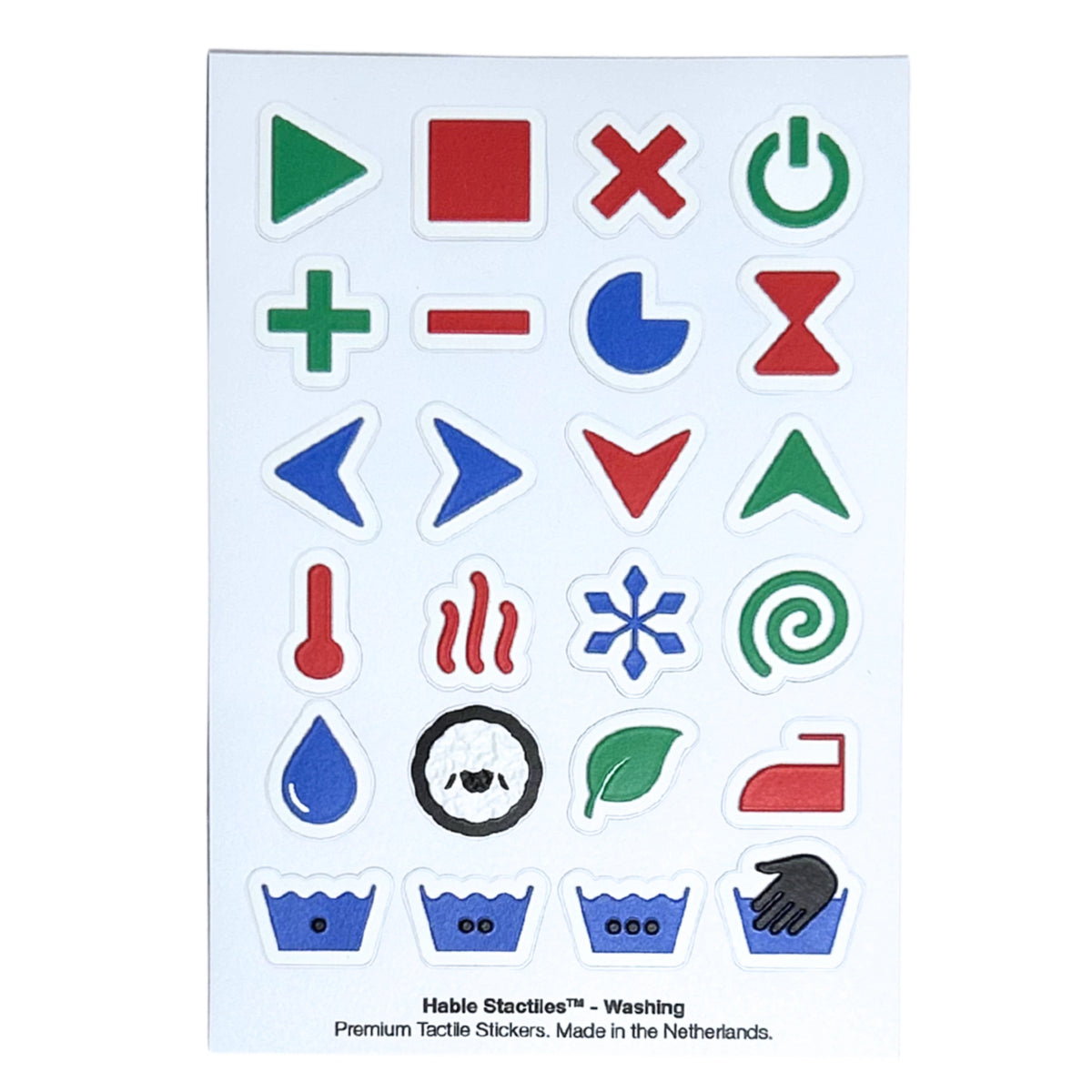 Top-down view of the "Hable Stactiles - Washing" sticker sheet. It contains colorful laundry and washing machine symbols, including power buttons, play/pause, temperature controls, heat lines, snowflake, eco leaf, wool cycle, iron, and wash tub water level indicators.