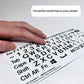 A close-up, angled photograph of a person's hand moving across a sheet of QWERTY keyboard stickers. The shot highlights the significant 3D height of the black letters and symbols, which provides clear tactile feedback for touch typing. A text overlay at the top reads: "The perfect tactile feel to every sticker."