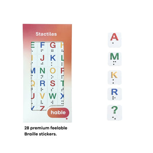 The Hable Stactiles packaging for the Braille set is shown next to five individual sample stickers arranged vertically: a red "A", a green "M", a yellow "K", a blue "R", and a green question mark. Each sticker features the printed character with the matching Braille dots embossed below it. Text at the bottom reads, "28 premium feelable Braille stickers."
