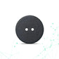 Black button with two holes on a white background
